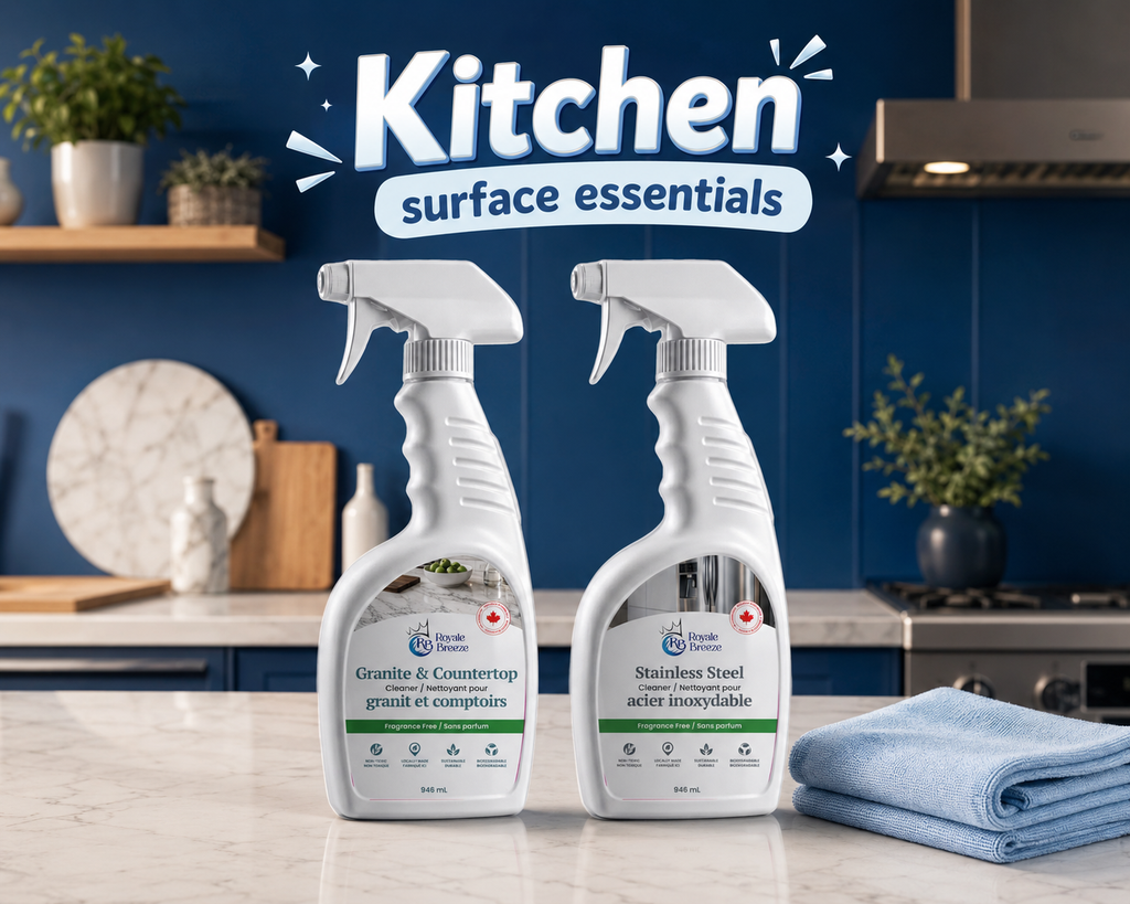Two bottles of 'Kitchen Surface Essentials' cleaning spray on a kitchen counter with a blue wall background.